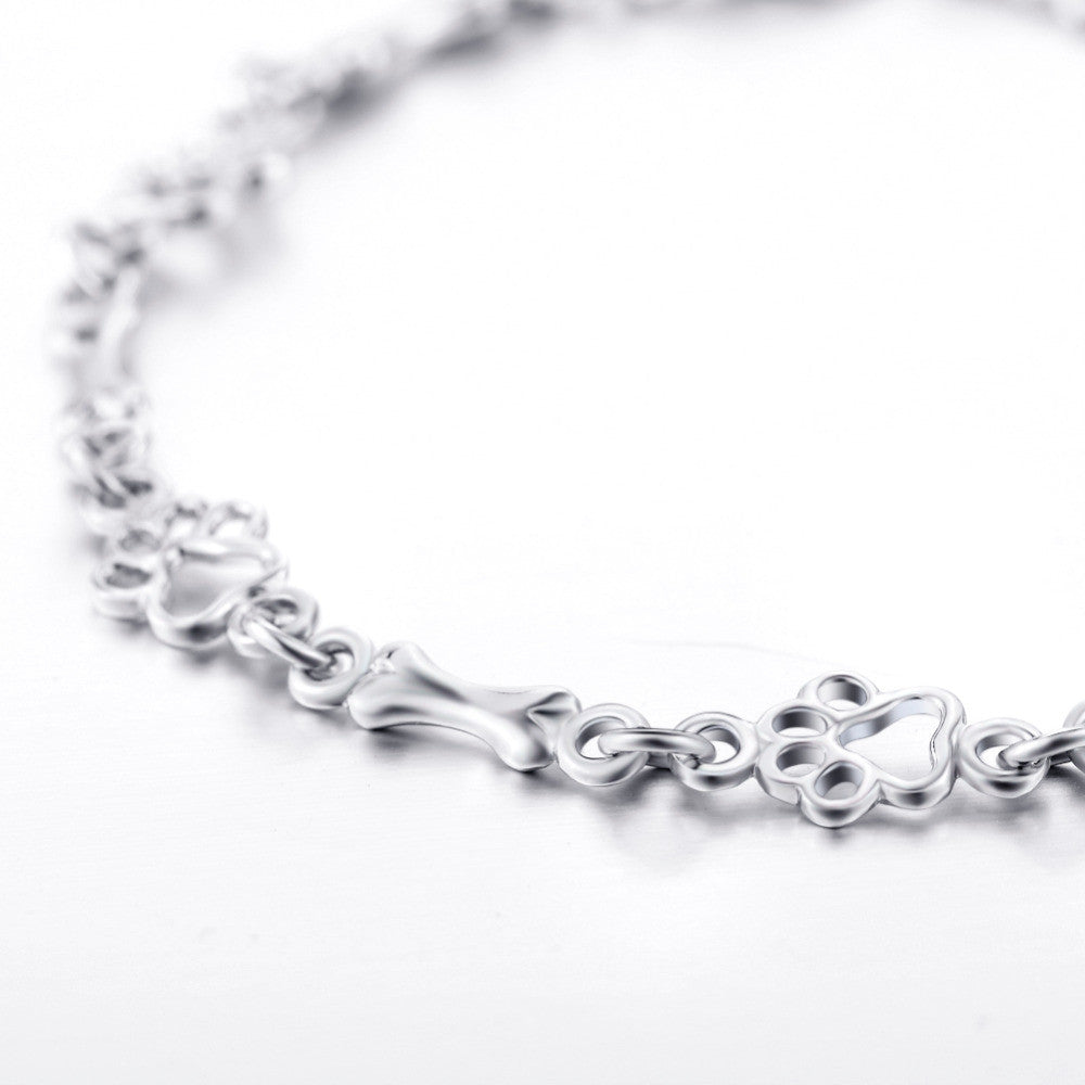 Armband mit Anhänger aus Silber mit Hundepfoten und -knochen